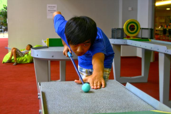 Kind spielt Pit-Pat, eine Kombination aus Billard und Minigolf, im Monki Park.